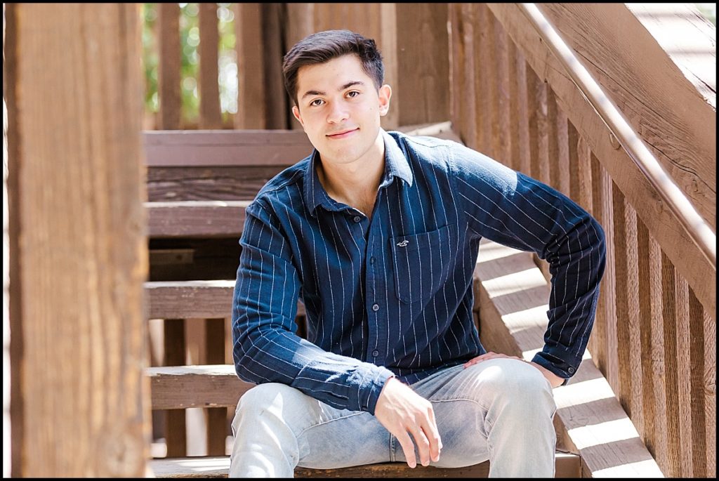 Boy sitting on stairs during High School Senior Portrait at Heritage Square in Phoenix